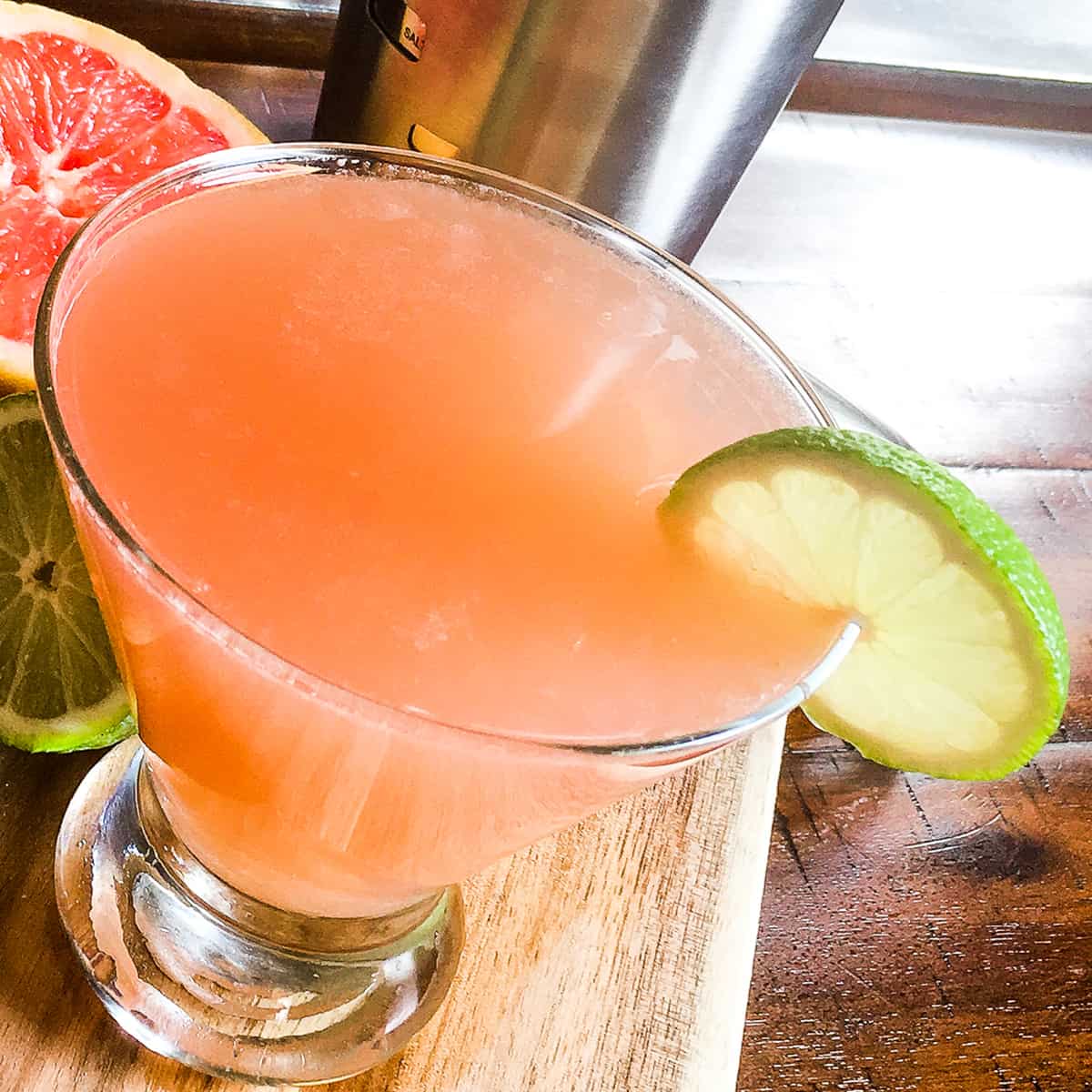 Pink grapefruit martini garnished with lime wedge