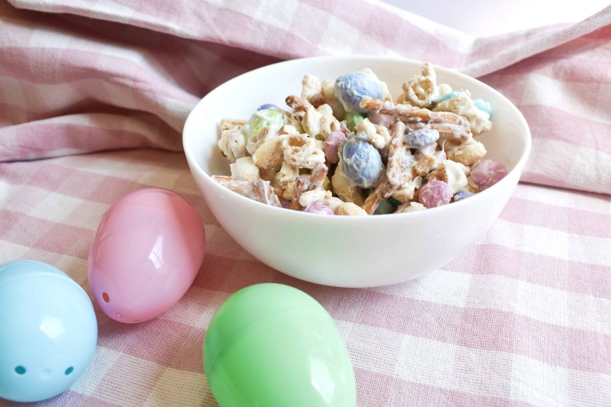 Bunny Bait Easter Snack Mix in white bowl with pink and white tablecloth and easter eggs