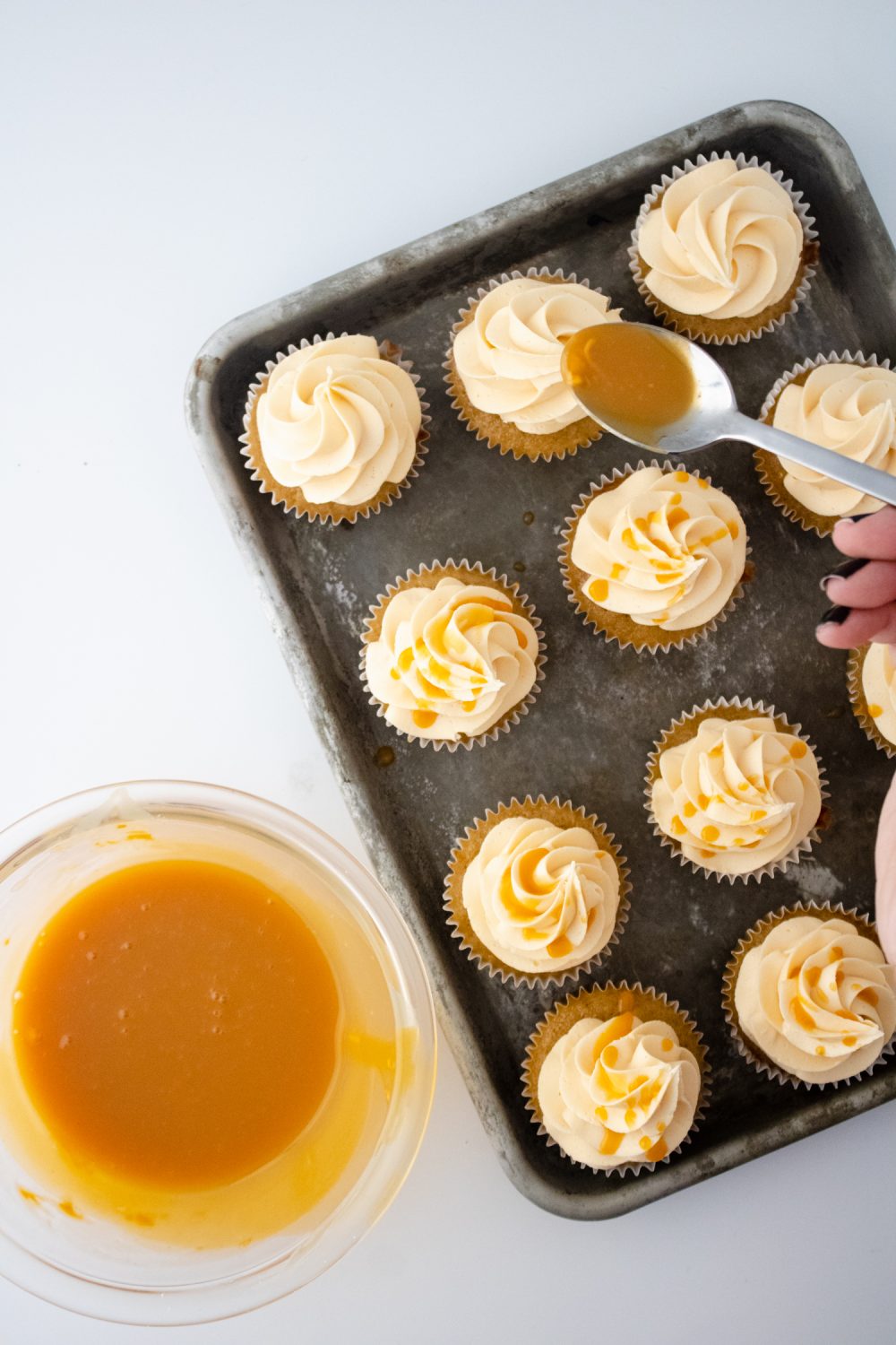 adding butterscotch sauce to butterbeer cupcakes
