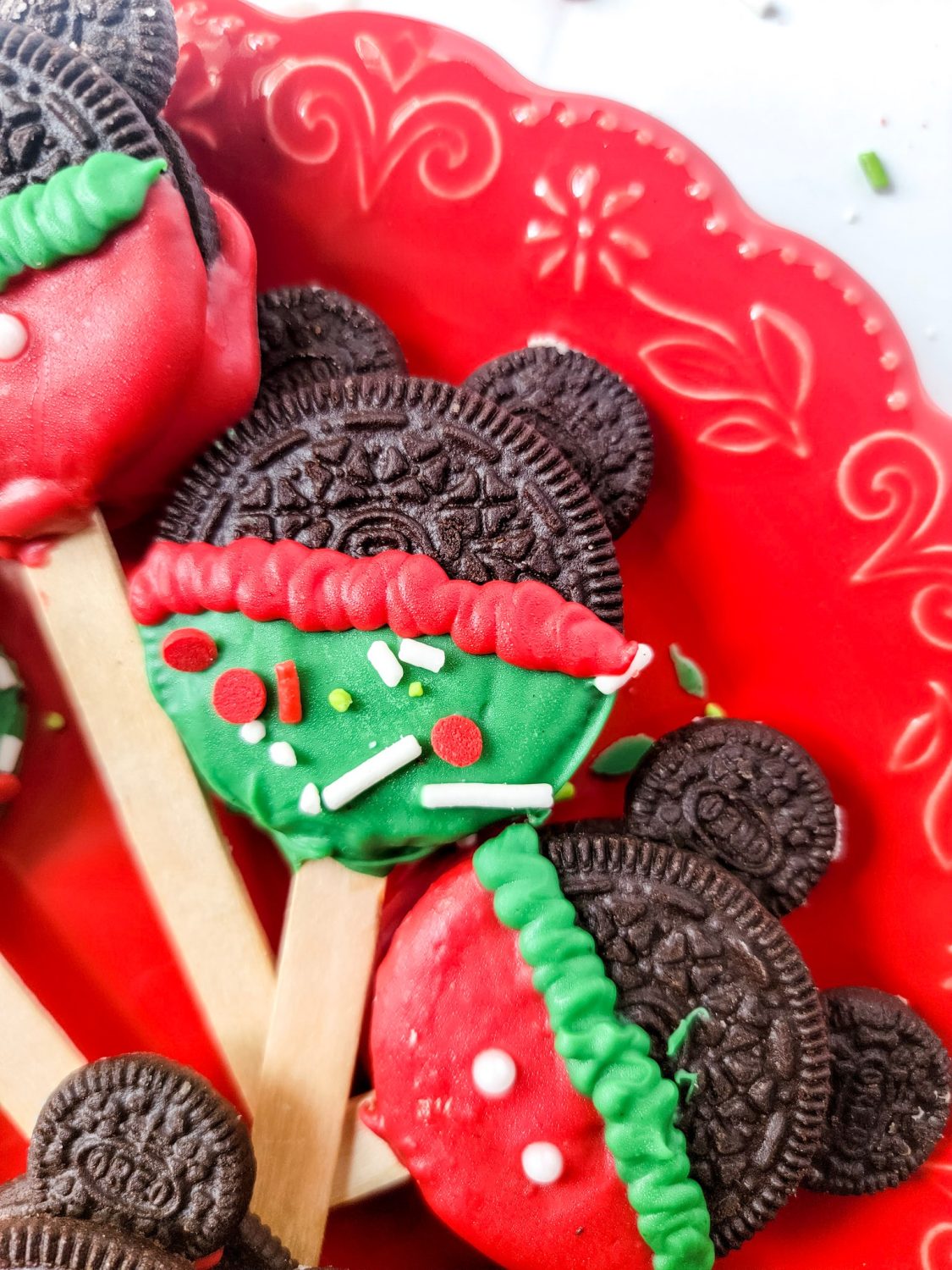 holiday mickey mouse oreo pops on red serving tray with sprinkles
