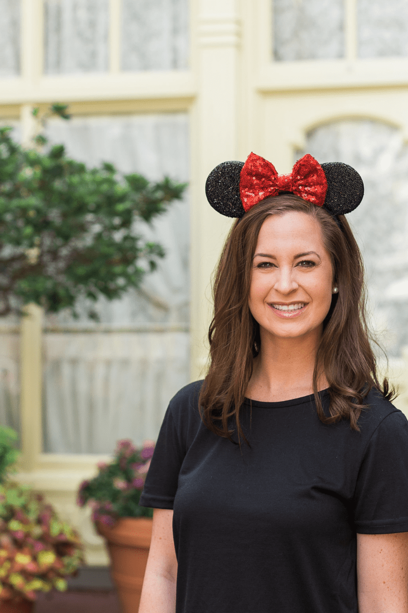 Why You Should Use a Travel Agent for Your Disney Vacation - red and black mickey ears on female with brown hair wearing black top on Main Street USA in Magic Kingdom