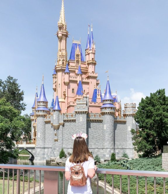 rose-gold-disney-loungefly-backpack-in-front-of-castle